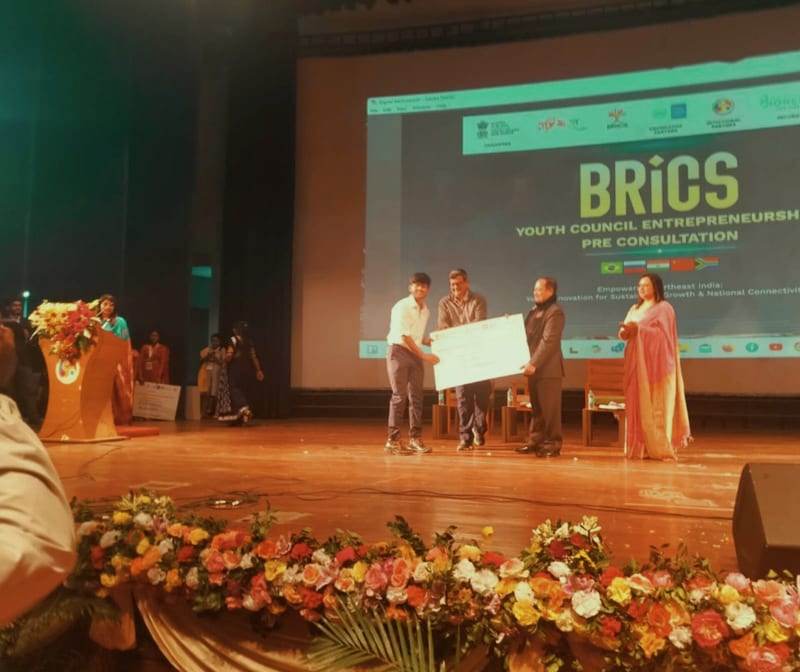 Karthikeya receiving the Best Startup Founder cheque on the BRICS stage